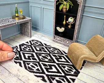 May include: Miniature dollhouse furniture set with a black and white patterned rug, a black bookshelf, a small table, and a tan chair. The bookshelf has decorative white accents and holds a plant, globe, and other items.