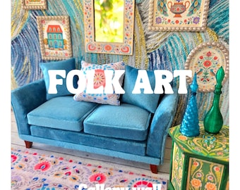 May include: A miniature living room scene featuring a blue velvet sofa with patterned pillows, a green side table with two glass bottles, and a rug with floral motifs. The wall displays framed art prints and a mirror with the text FOLK ART.