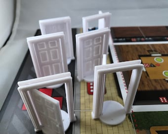 May include: Five white plastic doors with a raised design, standing on a game board with red and white stripes. The doors are different sizes and some are open.