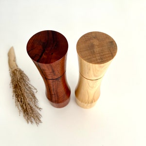 Birdseye view of wooden cylindrical shape salt and pepper grinders made from Australian Jarrah burl and Norfolk island pine timbers