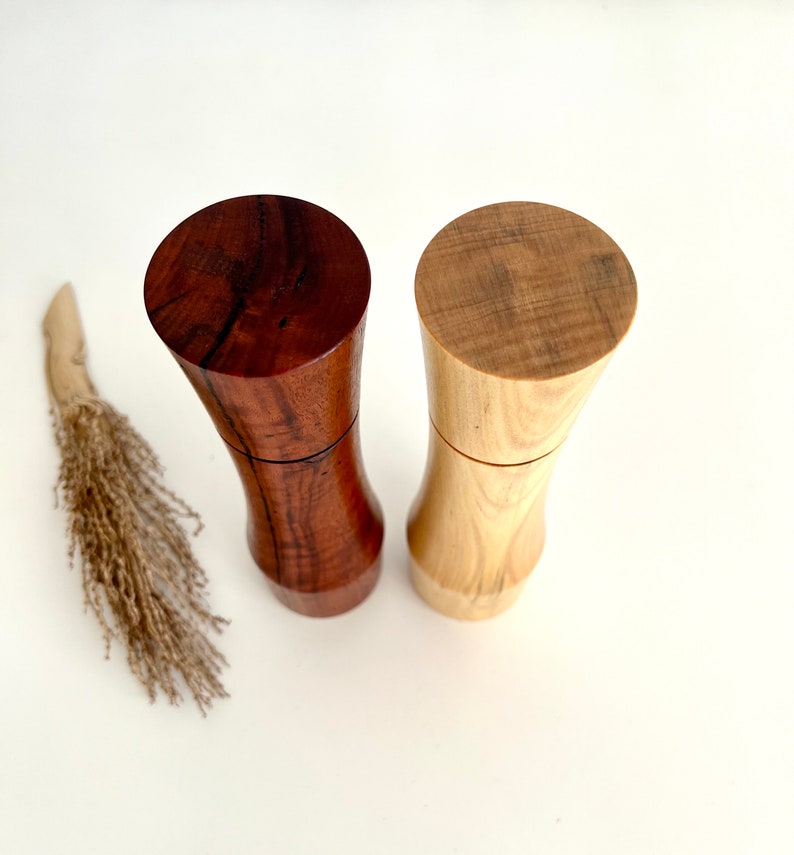 Birdseye view of wooden cylindrical shape salt and pepper grinders made from Australian Jarrah burl and Norfolk island pine timbers