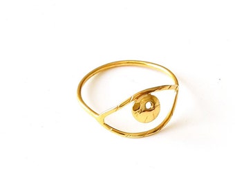 May include: A gold-colored ring with an eye design. The ring features a circular band and an open eye shape with a detailed iris. The eye is outlined with a thin gold band, creating a minimalist and artistic aesthetic.