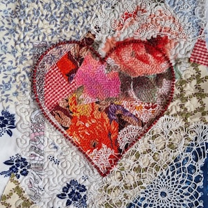 Könnte beinhalten: Eine rote herzförmige Patchwork-Decke mit verschiedenen Stoffen, darunter Spitze, Blumenmuster und Gingham. Die Decke besteht aus vielen verschiedenen Stoffstücken, die zusammengenäht wurden.
