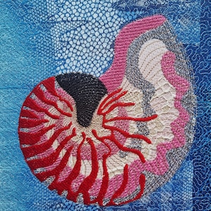 May include: An embroidered nautilus shell in red, pink, black, grey, and cream. The shell is set against a textured blue background with lace-like patterns, creating a striking contrast. The artwork is detailed.