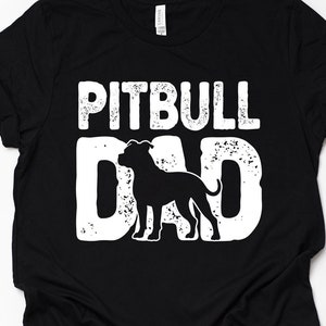 Pode incluir: Camiseta preta com texto branco que diz "Pitbull Dad" e uma silhueta de um cão pitbull.