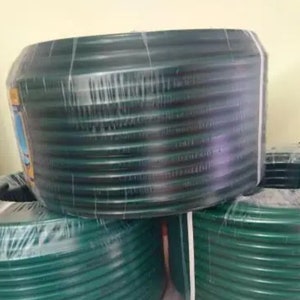 K&ouml;nnte beinhalten: Nahaufnahme einer Rolle gr&uuml;ner Gartenschlauch, die in Plastik verpackt ist. Der Schlauch ist fest aufgerollt und scheint aus strapazierf&auml;higem Material zu sein.