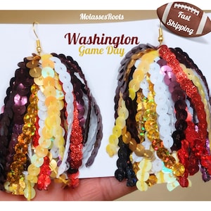 May include: Gold-tone earrings with cascading rows of sequins in burgundy, gold, white, and red. The earrings are designed with the text "Washington Game Day". A football graphic with "Fast Shipping" is also present.