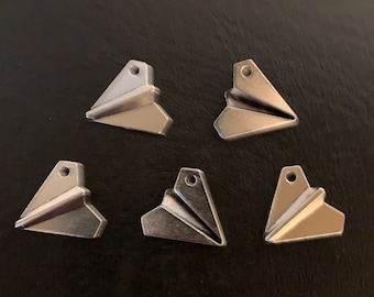 May include: Five silver paper airplane charms with a hole at the top for attaching to a necklace or bracelet.