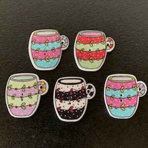 May include: Six colorful wooden buttons shaped like mugs with different patterns. The mugs are decorated with stripes, polka dots, and floral designs.