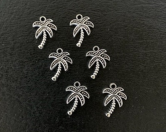 May include: Seven silver palm tree charms with a detailed design. The charms are small and perfect for adding a tropical touch to jewellery or crafts.