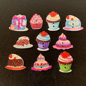 May include: Assortment of colorful wooden buttons shaped like cupcakes and a gift box. The buttons have a variety of designs and colors, including pink, blue, green, and yellow.