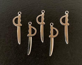May include: Five silver sword charms with a detailed design. The charms are all the same size and shape, and they are hanging from a black background.