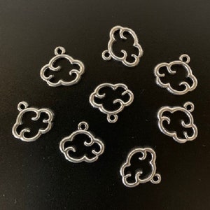 May include: Nine silver metal charms shaped like clouds. The charms have a delicate, openwork design and are perfect for adding a touch of whimsy to jewelry or crafts.