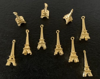 May include: Twelve gold Eiffel Tower charms, perfect for adding a Parisian touch to jewelry or crafts.