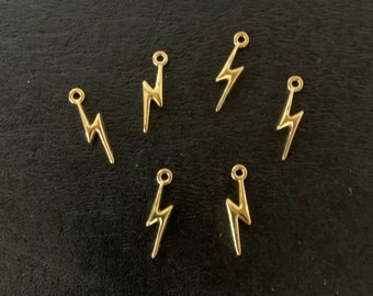 May include: Six gold-colored lightning bolt charms with a loop at the top for attaching to jewelry or other crafts.