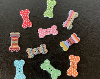 May include: Assortment of colorful bone-shaped buttons with various patterns, including polka dots, stripes, and geometric designs.