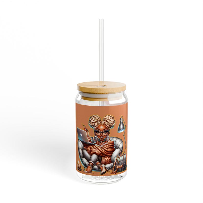 May include: A glass tumbler with a bamboo lid and straw. The tumbler features a colorful illustration of a woman sitting in a chair with a laptop, a lamp, and a purse. The background is a light orange color.