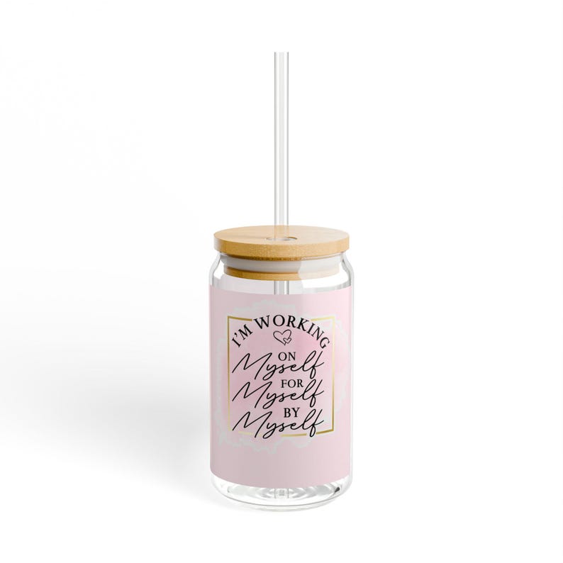 May include: A pink glass tumbler with a bamboo lid and a clear straw. The tumbler has a gold square frame around the text "I'm Working On Myself For Myself By Myself" with two small hearts above the first "Myself".