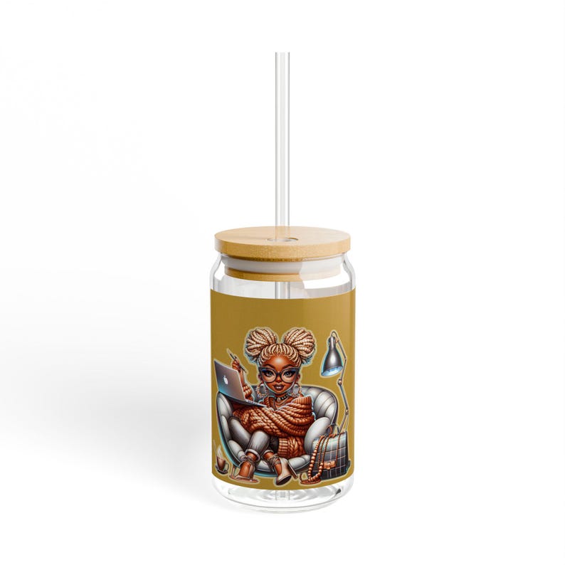May include: A clear glass tumbler with a bamboo lid and straw. The tumbler features a colorful illustration of a woman with braids sitting in a chair with a laptop, a lamp, and a backpack. The background is a solid mustard yellow.