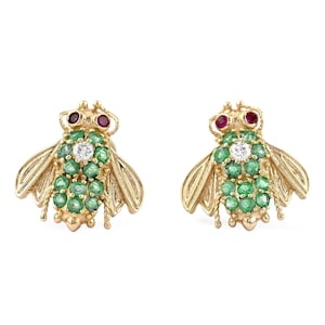 May include: A pair of gold bee earrings set with emerald green and ruby red stones. The bees have a diamond in the centre of their bodies.