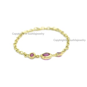 May include: A delicate gold chain ring featuring three oval and round pink gemstones. The ring is a fine jewelry piece with a minimalist design. The text "Copyright of Sushilajewelry" is visible.