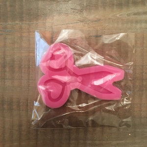 May include: Pink silicone mold shaped like a pair of scissors with heart-shaped handles.