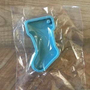 May include: A blue silicone mould shaped like a Christmas stocking. The mould has a small hole at the top for hanging.