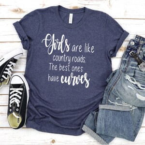 May include: A navy blue t-shirt with the text "Girls are like country roads. The best ones have curves" in white lettering.