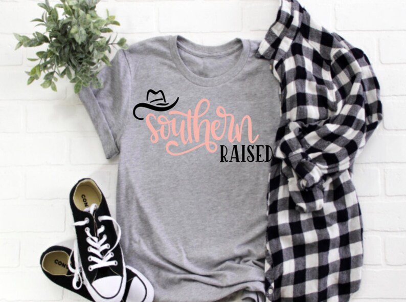 May include: A gray t-shirt with a black cowboy hat graphic and the text "Southern Raised" in pink lettering.