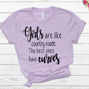 May include: A light purple t-shirt with the text "Girls are like country roads. The best ones have curves" printed in black.