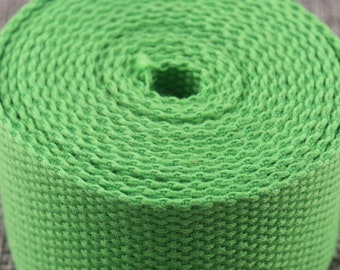 May include: A roll of bright green woven webbing, a type of heavy-duty fabric used for straps, belts, and other applications.
