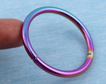 May include: A rainbow-colored metal ring with a seamless finish. The ring is open and has a smooth, polished surface.