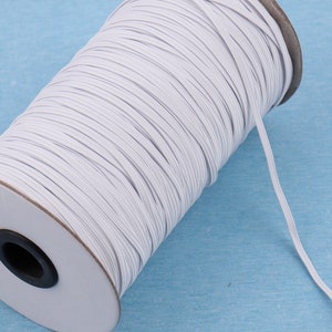 Puede incluir: Una bobina de cord&oacute;n el&aacute;stico blanco, enrollada alrededor de un n&uacute;cleo de cart&oacute;n. El cord&oacute;n se utiliza para coser y proyectos de artesan&iacute;a.