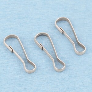 May include: Three silver-toned metal lanyard hooks, each featuring a teardrop-shaped loop at the base and a spring-loaded gate mechanism at the top, designed for attaching items securely to keychains, bags, or other accessories.
