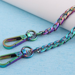 May include: A rainbow iridescent chain with two metal clasps. The chain is a curb style with a flat, rectangular link.