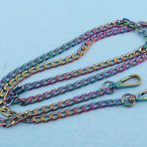 May include: A rainbow iridescent chain with two lobster clasps. The chain is made of metal and has a curb link design.