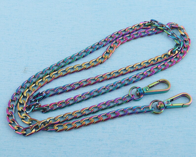 May include: A rainbow iridescent chain with two lobster clasps. The chain is made of metal and has a curb link design.