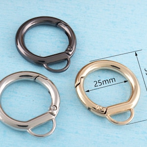 May include: Three metal key rings in different finishes: black, silver, and gold. The gold key ring is 25 mm in diameter and 39 mm in length.