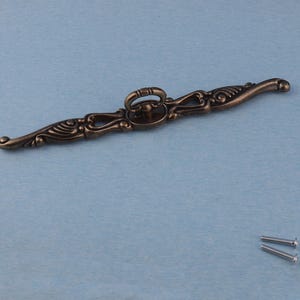 May include: A white ceramic mug with a black handle and the text "But First, Coffee" in a black, handwritten-style font. The mug is on a white surface.