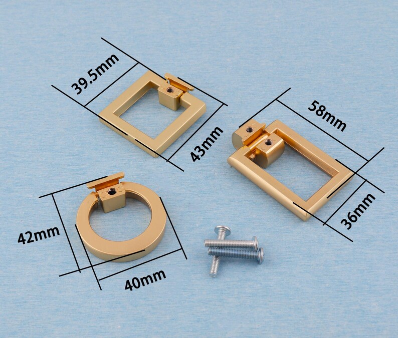 Op de afbeelding: Drie goudkleurige kastgrepen in verschillende vormen: een vierkant (43 mm x 39,5 mm), een rechthoek (58 mm x 36 mm) en een cirkel (42 mm x 40 mm). Inclusief montageschroeven. De hardware wordt weergegeven op een lichtblauwe ondergrond.