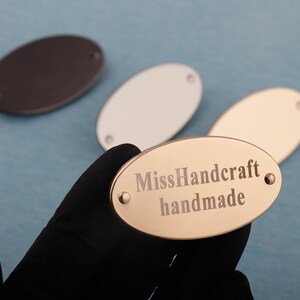 Etiqueta de metal personalizada para bolso de 47 x 26 mm, etiquetas ovaladas en blanco con pies, texto de logotipo personalizado para bolsos, logotipo de bolso grabado con láser personalizado