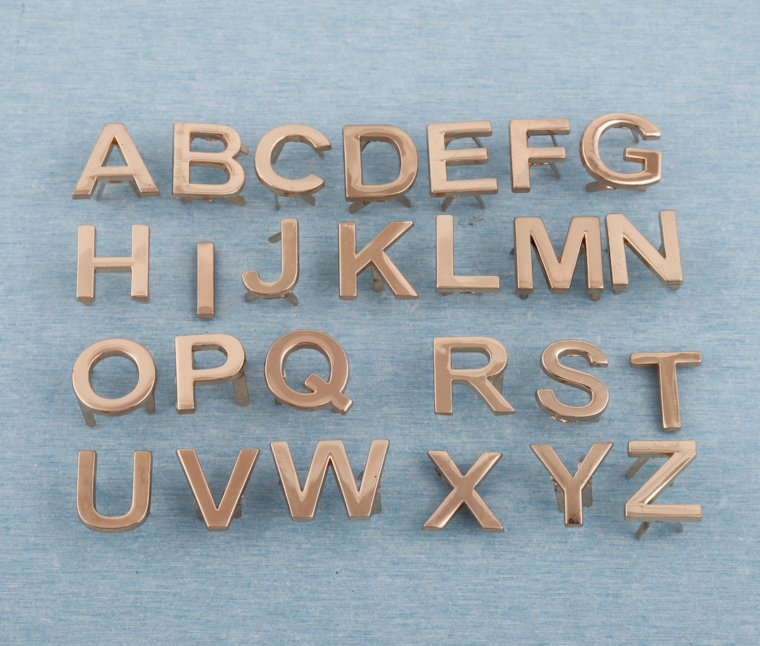 Etichetta per borsa con lettera inglese in metallo color oro chiaro