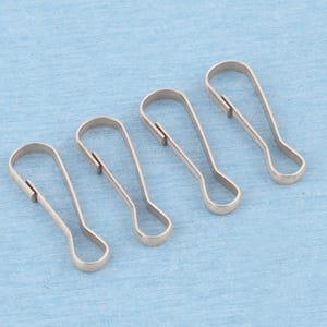 May include: Four silver-toned metal lanyard hooks, each featuring a teardrop-shaped loop at the bottom and a spring-loaded gate mechanism at the top, arranged in a diagonal row to display their uniform construction and metallic finish.