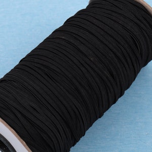 Puede incluir: Un carrete de cord&oacute;n el&aacute;stico negro, enrollado firmemente en un n&uacute;cleo de cart&oacute;n.