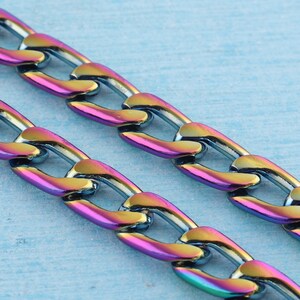 May include: A close-up of a chain necklace with iridescent links. The chain is made of metal and has a curb link design. The links are a mix of blue, green, purple, and pink.
