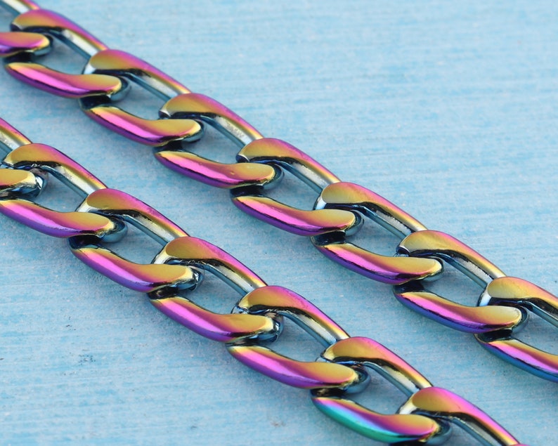 May include: A close-up of a chain necklace with iridescent links. The chain is made of metal and has a curb link design. The links are a mix of blue, green, purple, and pink.