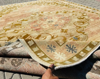 Puede incluir: Una alfombra beige y marrón con estampado y flecos blancos. La alfombra está doblada por la mitad, revelando la parte inferior, que es de color beige más claro.