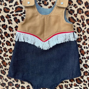 Macacão Cowboy Baby - com franjas e botões de pérola. Cores e materiais são personalizáveis.