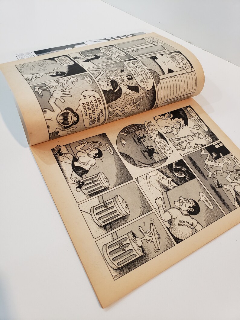 May include: A comic book open to a double-page spread with black and white cartoon illustrations. The panels depict various scenes with speech bubbles. Text includes "EEK! MISS HINTON! THERE'S A NAKED MAN IN OUR LOCKER ROOM!" The pages have a yellowed hue.