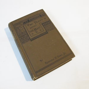 May include: A brown book with the title "Two Years Before the Mast" by Richard H Dana Jr. The cover features decorative illustrations in black and white.